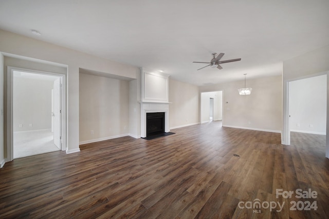 unfurnished living room with ceiling fan, a large fireplace, and dark hardwood / wood-style flooring