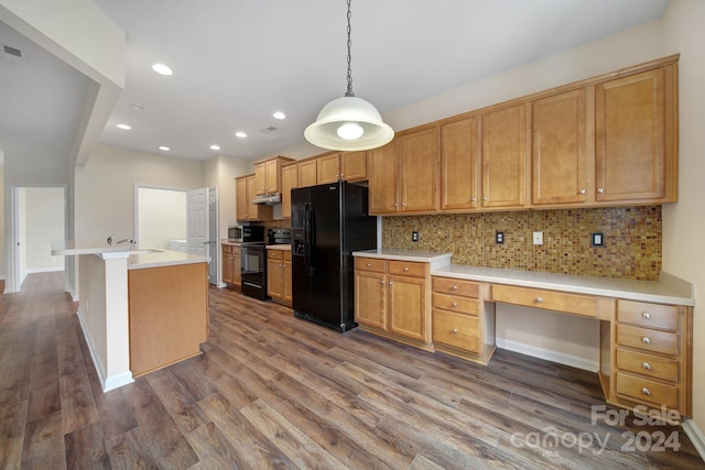 kitchen featuring tasteful backsplash, a center island with sink, black appliances, hanging light fixtures, and dark hardwood / wood-style flooring