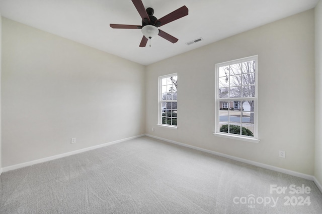 unfurnished room with ceiling fan and carpet