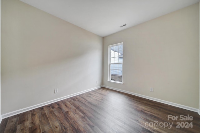 unfurnished room with dark wood-type flooring