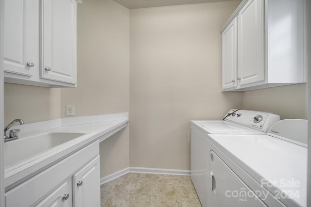 laundry room featuring cabinets, sink, and independent washer and dryer