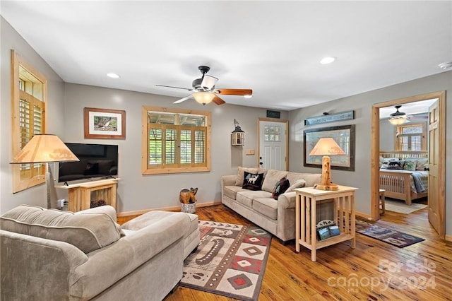 living room featuring ceiling fan and light hardwood / wood-style flooring