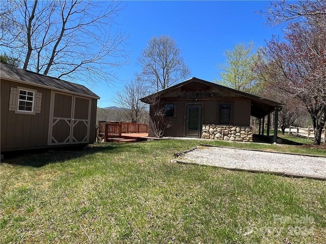 rear view of house with a lawn and a shed