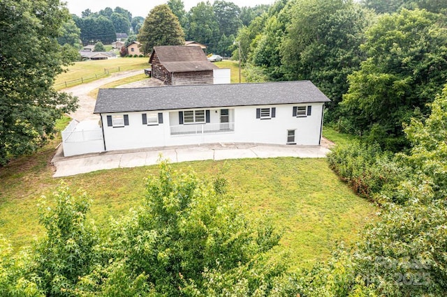 rear view of house featuring a lawn and a patio area