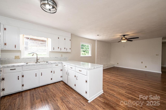 kitchen with kitchen peninsula, sink, dark hardwood / wood-style floors, ceiling fan, and white cabinetry