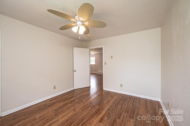 empty room featuring a textured ceiling, ceiling fan, and dark wood-type flooring