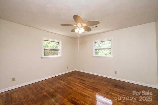 spare room featuring a wealth of natural light, hardwood / wood-style floors, and ceiling fan