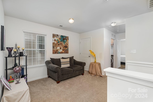 carpeted living room with washer / dryer