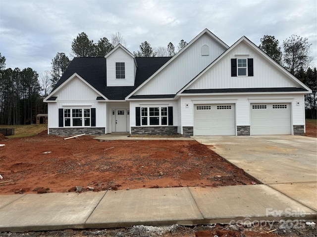 view of front of property featuring stone siding and concrete driveway