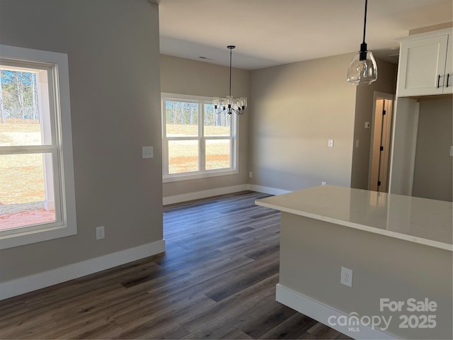 kitchen with a healthy amount of sunlight, baseboards, white cabinets, and dark wood-style flooring