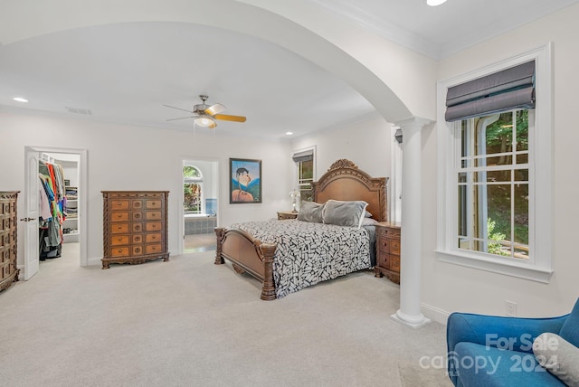 bedroom with ceiling fan, crown molding, a spacious closet, decorative columns, and carpet floors