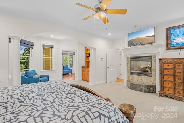 carpeted bedroom featuring arched walkways, recessed lighting, a multi sided fireplace, and crown molding