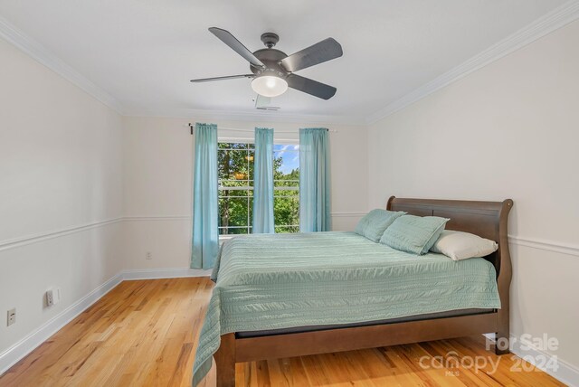 bedroom featuring ceiling fan, ornamental molding, and light hardwood / wood-style floors