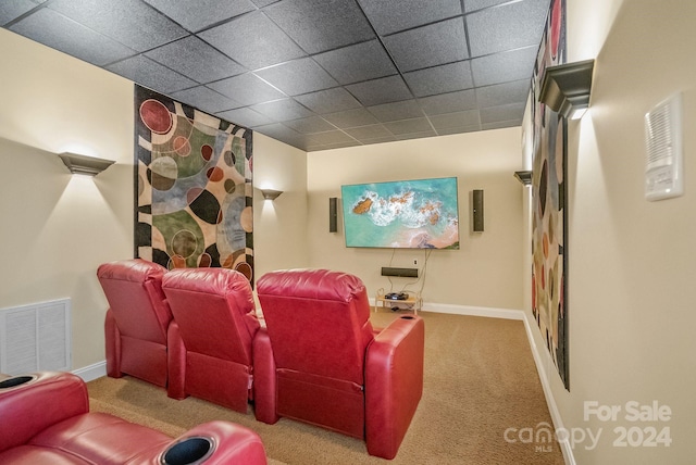 carpeted cinema featuring a paneled ceiling, baseboards, and visible vents