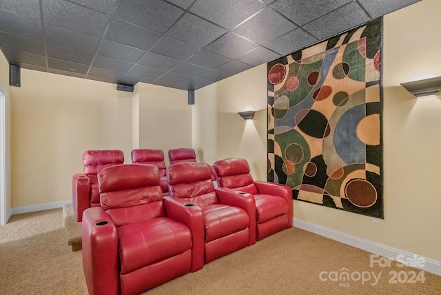 carpeted cinema with a paneled ceiling