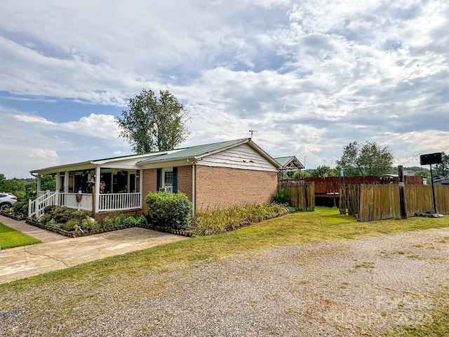 view of side of home featuring covered porch