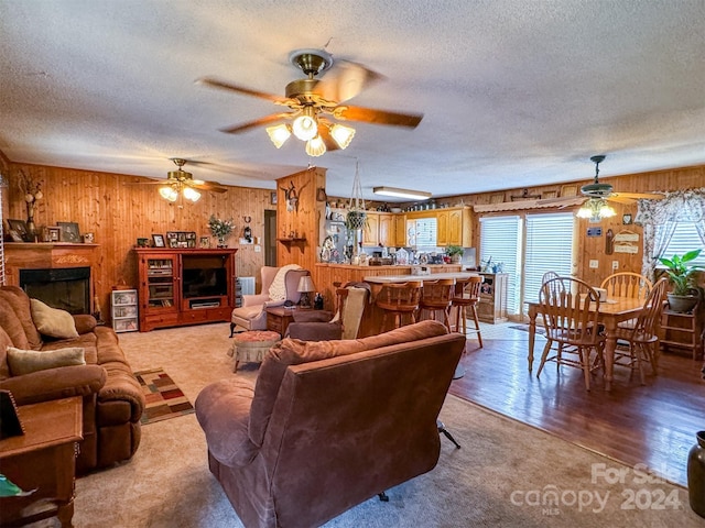 living room with ceiling fan, wood-type flooring, and a textured ceiling