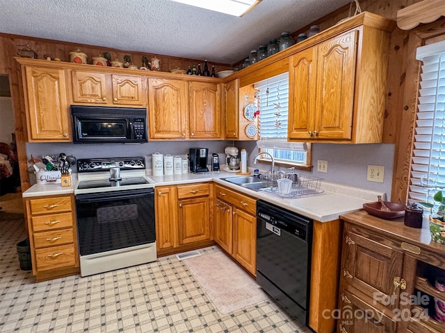 kitchen with sink, a textured ceiling, and black appliances