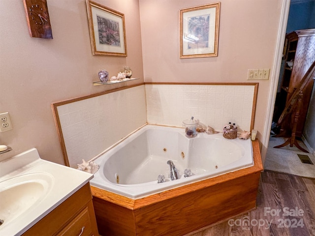 bathroom with hardwood / wood-style floors, a bathtub, and vanity