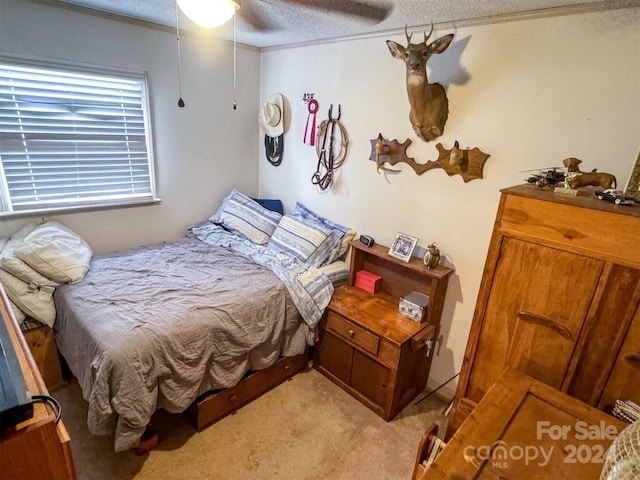 carpeted bedroom featuring ceiling fan and a textured ceiling