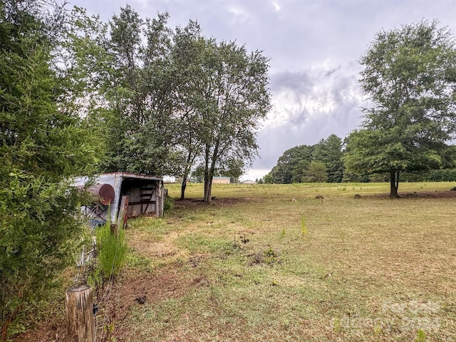 view of yard with a rural view and an outdoor structure