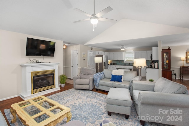 living room with ceiling fan, vaulted ceiling, and dark hardwood / wood-style flooring