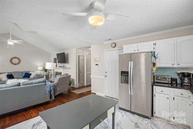 kitchen featuring white cabinets, decorative backsplash, stainless steel fridge, and a textured ceiling