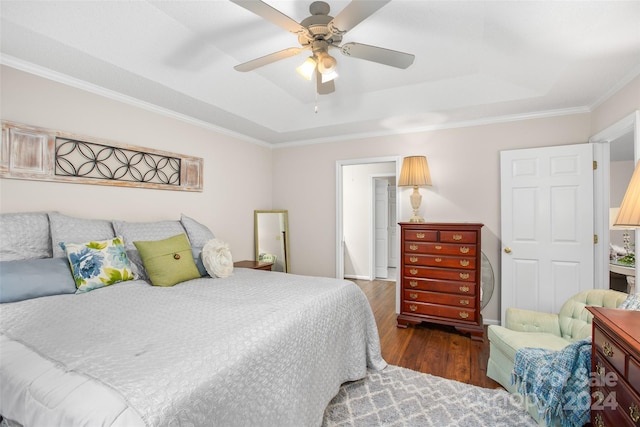 bedroom featuring a raised ceiling, ceiling fan, dark hardwood / wood-style flooring, and ornamental molding