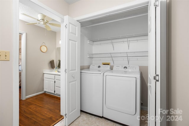 laundry area with ceiling fan, independent washer and dryer, and light hardwood / wood-style floors