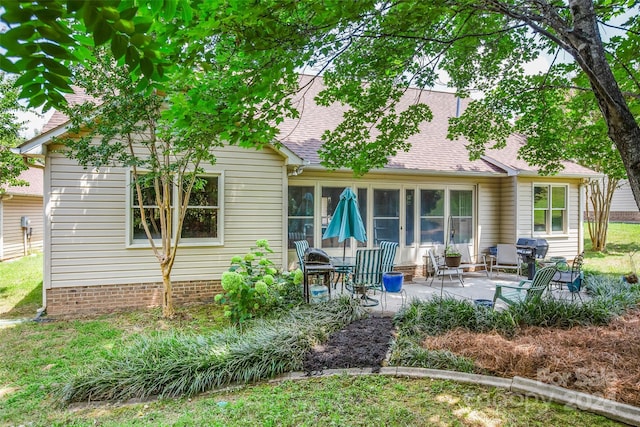 rear view of house featuring a patio area and a sunroom