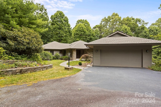 view of front of property with a front yard and a garage