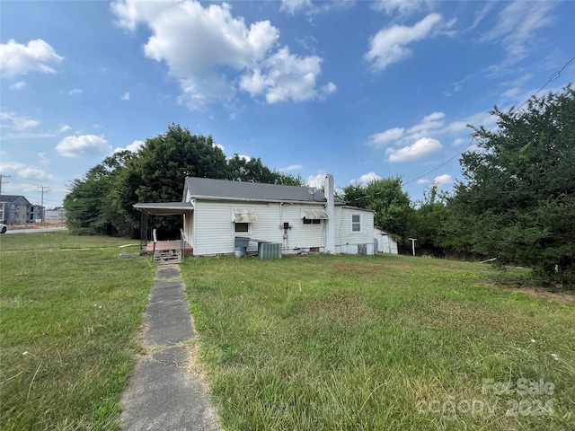 back of property with cooling unit and a yard