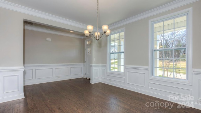 unfurnished room with plenty of natural light, a notable chandelier, dark hardwood / wood-style flooring, and ornamental molding