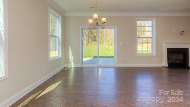 unfurnished living room with a wealth of natural light, hardwood / wood-style flooring, and a chandelier