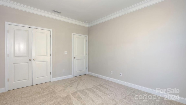 unfurnished bedroom with a closet, ornamental molding, and light colored carpet