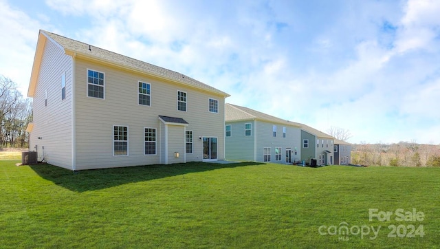 back of property featuring central AC unit and a lawn