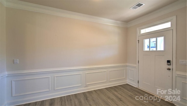 foyer entrance with a wainscoted wall, dark wood-type flooring, visible vents, and crown molding