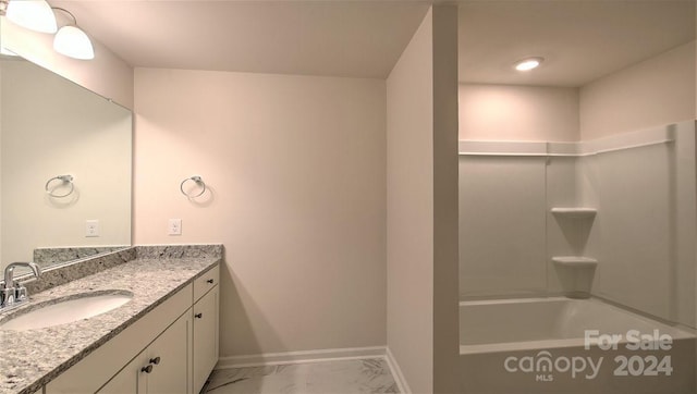 bathroom with marble finish floor, bathtub / shower combination, baseboards, and vanity