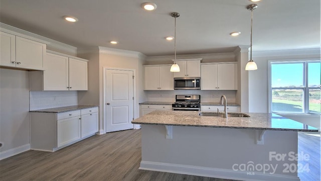 kitchen with appliances with stainless steel finishes, white cabinets, a sink, and ornamental molding