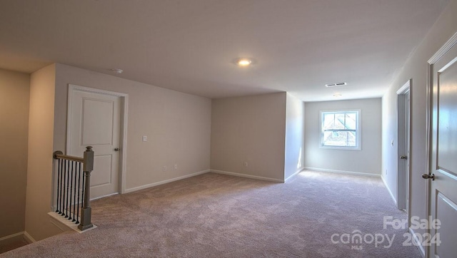 carpeted empty room featuring baseboards and visible vents