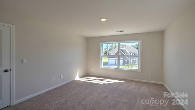 spare room featuring baseboards, visible vents, and carpet flooring