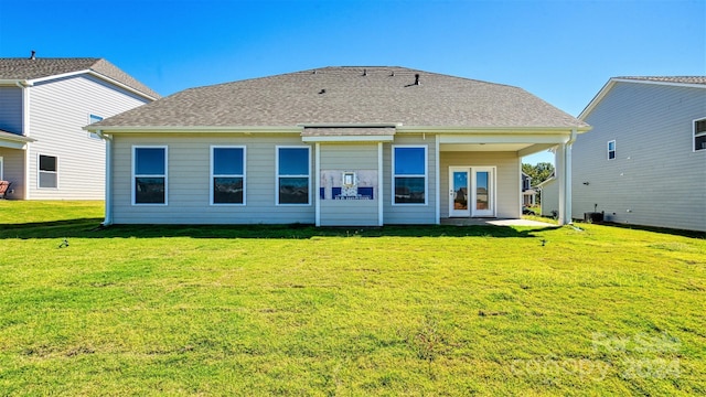 back of property with a shingled roof, french doors, a yard, and central AC unit