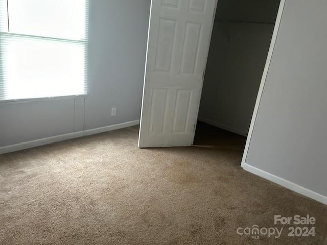 unfurnished bedroom with carpet and a closet