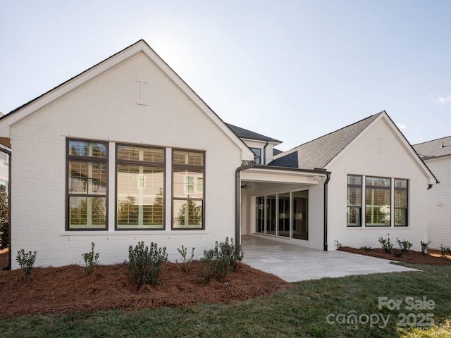 back of property featuring a patio and a lawn