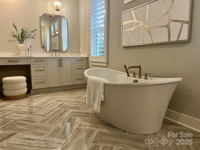 bathroom featuring a washtub, parquet floors, and vanity