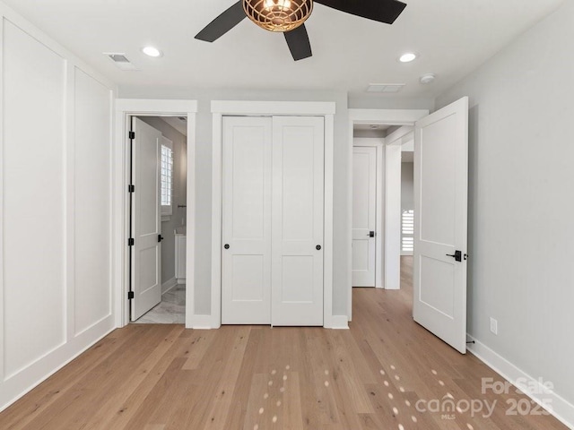 unfurnished bedroom with ensuite bathroom, light hardwood / wood-style floors, a closet, and ceiling fan