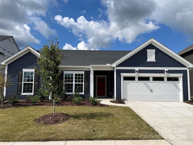 view of front of home featuring a front yard and a garage