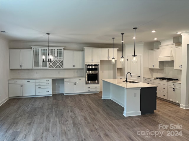 kitchen featuring sink, hanging light fixtures, and white cabinets