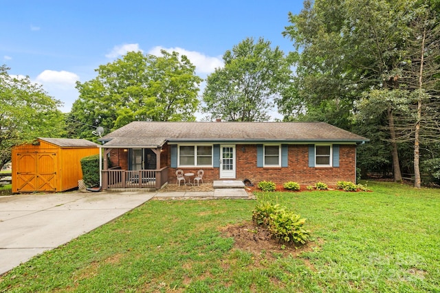 ranch-style house featuring a front yard, a porch, and a storage unit