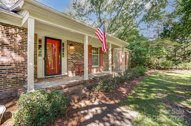 view of exterior entry featuring covered porch